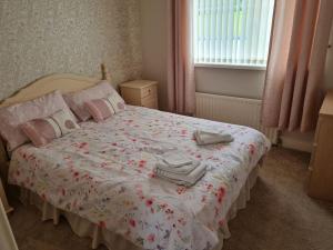 a bedroom with a bed with two towels on it at Hillview House in Bellaghy