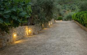 un camino de piedra con luces en la pared en Villa Haven United, en Palaia Epidavros