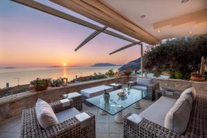 un patio con mesa y sillas y vistas al océano en Villa Haven United, en Palaia Epidavros