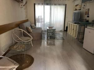 a living room with a couch and a table at Agréable studio Barcares in Le Barcarès