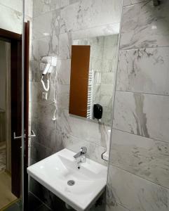 a bathroom with a white sink and a mirror at Hotel Casablanca in Goražde