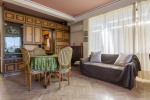 een woonkamer met een bank, een tafel en stoelen bij Acropolis View apartment 120sqm in Athene
