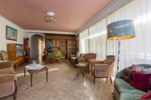 een woonkamer met banken en stoelen en een lamp bij Acropolis View apartment 120sqm in Athene