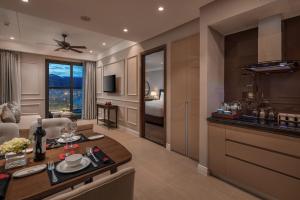 Luxury Beach Condo 5-star, Rooftop pool في دا نانغ: مطبخ وغرفة معيشة مع طاولة وأريكة