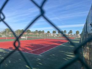 a tennis court seen through a chain link fence at Agréable studio Barcares in Le Barcarès +7 photos