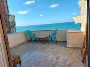 two chairs and a table on a balcony with the ocean at Haidar House a private rooms for men only at shared apartment غرف خاصه للرجال فقط in Alexandria