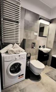 a bathroom with a washing machine and a toilet at Cozy RED ROSE Apartment, 2 rooms Down Town in Kraków