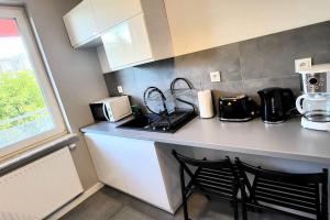 a kitchen with a counter with two chairs and a microwave at Cozy RED ROSE Apartment, 2 rooms Down Town in Kraków