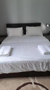 uma cama grande com lençóis brancos e almofadas em Shaftsbury residence cyberjaya studio suites with free parking em Cyberjaya