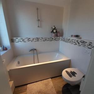 a white bathroom with a tub and a toilet at Ferienwohnung Alter Kräuterhof in Mildenau +31 photos