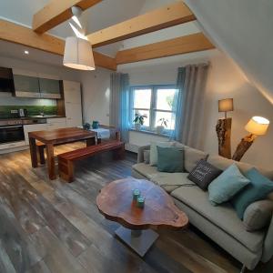 a living room with a couch and a table at Ferienwohnung Alter Kräuterhof in Mildenau