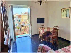 a dining room with a table and a balcony at La casa di Palma in Alassio