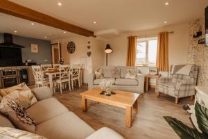 een woonkamer met een bank en een tafel bij Bennar Isa Cottages Dyffryn Ardudwy in Barmouth