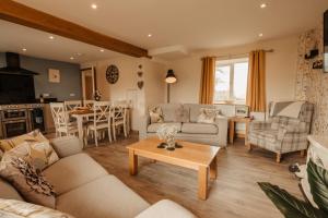 ein Wohnzimmer mit Sofa und Tisch in der Unterkunft Bennar Isa Cottages Dyffryn Ardudwy in Barmouth