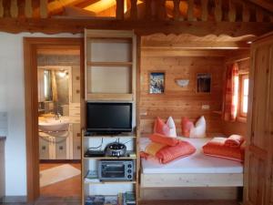 Habitación con cama, TV y baño. en Siegi's Ferienhütte en Fendels