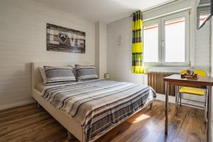 1 dormitorio con 1 cama, escritorio y ventanas en Apartments Nina, en Zadar