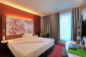 a hotel room with a bed and a television at IBB Hotel Ingelheim in Ingelheim am Rhein