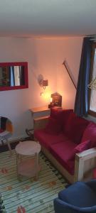 a living room with a red couch in a room at Duplex résidence ALDEBARAN RISOUL - 3 pièces - 8 personnes in Risoul