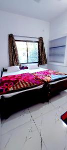 a large bed in a room with a window at Nilam Guest House in Bodh Gaya