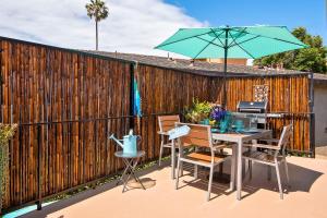 um pátio com uma mesa e um guarda-chuva em Hideaway Unit D em San Clemente