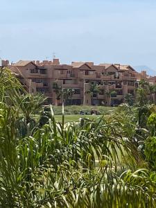 ein großes Apartmenthaus im Hintergrund mit Pflanzen in der Unterkunft Apartment Sol Dorado - Mar Menor Golf Resort in Torre-Pacheco