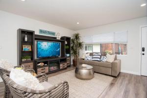 uma sala de estar com um sofá e uma televisão em Hideaway Unit D em San Clemente