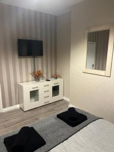 a bedroom with a bed and a flat screen tv at Beresford ground floor Seafront apartment in Southend-on-Sea