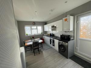 a kitchen with a stove and a table in it at Beresford ground floor Seafront apartment in Southend-on-Sea