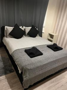 a bed with two black towels on top of it at Beresford ground floor Seafront apartment in Southend-on-Sea