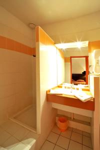 La salle de bains est pourvue d'un lavabo et d'une douche. dans l'établissement urban by balladins Perpignan, à Perpignan