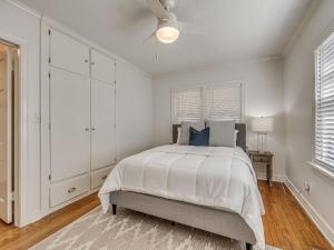 a white bedroom with a bed and a ceiling fan at The Charming Pecan Place! in Oklahoma City