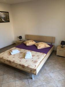 een slaapkamer met een bed met twee handdoeken erop bij Miro Apartmani in Ražanac