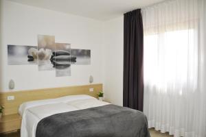 - une chambre avec un lit et une grande fenêtre dans l'établissement La Quiete, à Tremosine