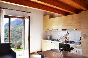 une cuisine avec des placards en bois et une grande fenêtre dans l'établissement La Quiete, à Tremosine
