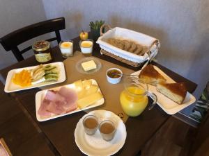 uma mesa com um pequeno-almoço de queijo, pão e sumo de laranja em Eply dort 