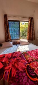een slaapkamer met 2 bedden en een raam bij Nilam Guest House in Bodh Gaya