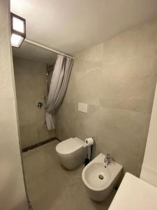 a white bathroom with a toilet and a sink at Bilocale nell’antico ghetto ebraico in Ferrara