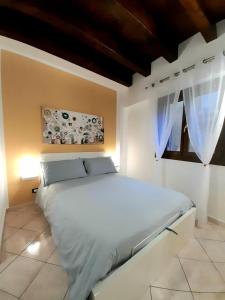 ein Schlafzimmer mit einem weißen Bett und einem Fenster in der Unterkunft I Vicini del Re Holiday Home in Palermo