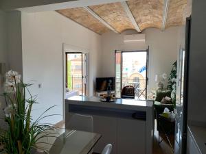 uma cozinha com um balcão e uma sala de estar em Espectacular Tarragona Corsini Apartment-2, en el centro, con parking em Tarragona