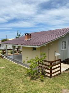 a small house with a red roof and a yard at CASA GAMBOA BEACH in Garopaba