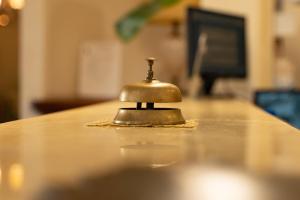 una campana seduta sopra un tavolo di legno di Hotel Ristorante Vecchia Vibo a Vibo Valentia