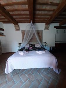 ein Schlafzimmer mit einem weißen Bett mit einem Netz darauf in der Unterkunft Bed & Breakfast Villa Monterosso in Sassoferrato