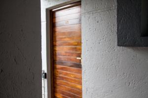 a wooden door is seen through a doorway at Zenko Suave- 12 Madison West in Johannesburg