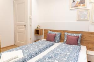 1 Schlafzimmer mit 2 Betten mit blauen und violetten Kissen in der Unterkunft Modern 3 room apartment in a prime location in Wien