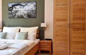 Schlafzimmer mit einem Bett und einem Holzschrank in der Unterkunft Appartement Uttied mit Terrasse und Garten - 4 Sterne DTV in Rambin