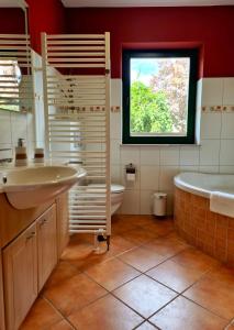 a bathroom with a sink and a tub and a window at Appartement Uttied mit Terrasse und Garten - 4 Sterne DTV in Rambin