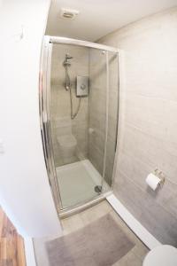 a shower with a glass door in a bathroom at Annexe with Sea View, Private Entrance & Parking - FOLKESTONE in Folkestone