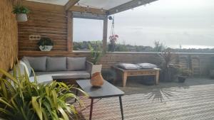 a patio with a couch and a table on a deck at Annexe with Sea View, Private Entrance & Parking - FOLKESTONE in Folkestone