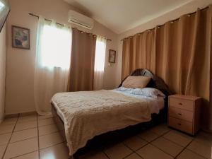 een slaapkamer met een bed en een raam bij CORONADO VILLA VICTORIA in San Carlos