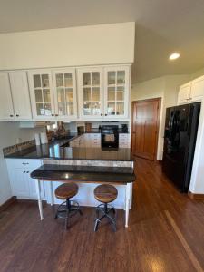 uma cozinha com armários brancos e um balcão preto em Friendly Falls Staycation em Sioux Falls